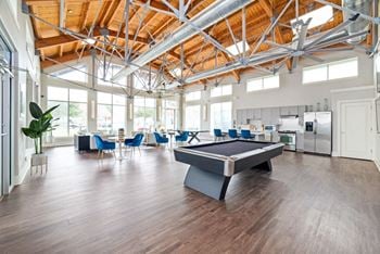 A game room with a pool table in the middle